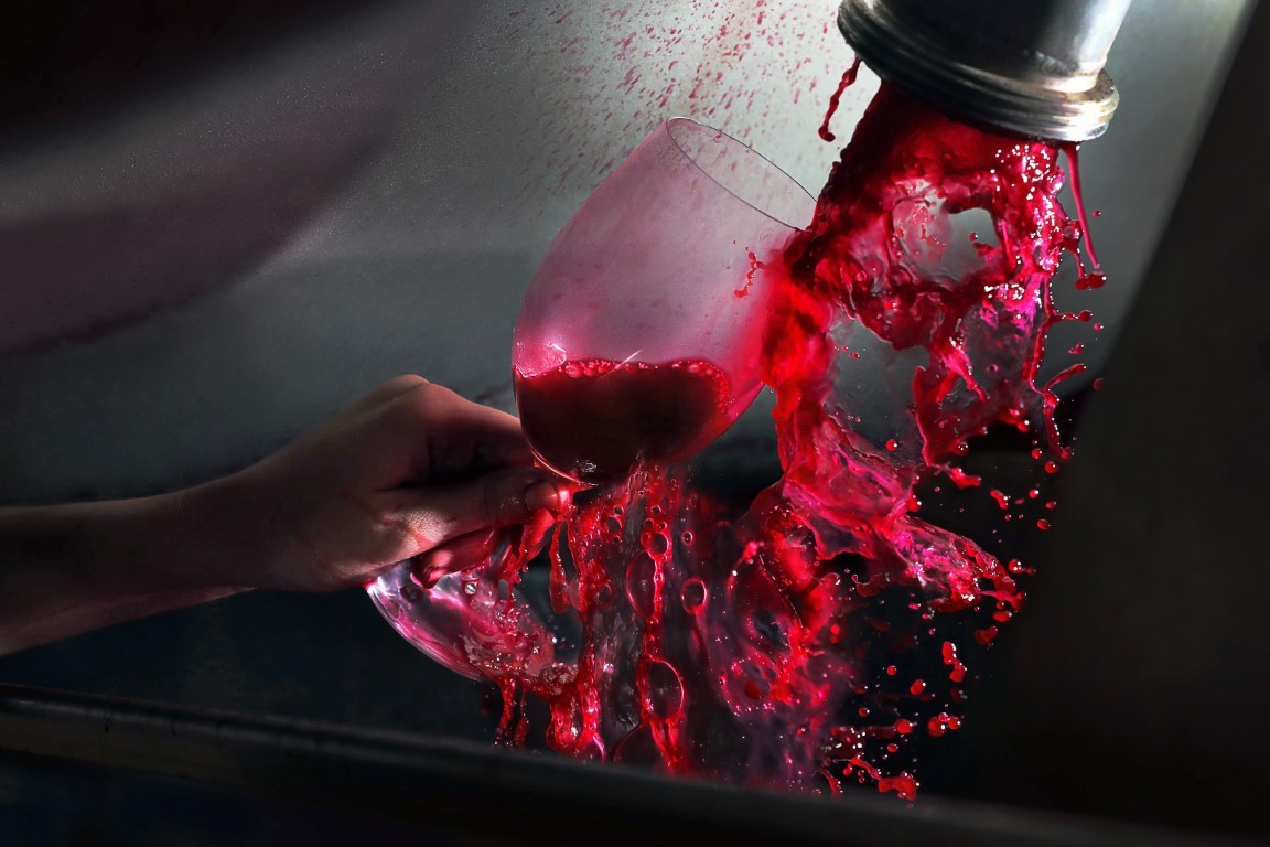 Red wine filling a wine glass straight out of the winery press